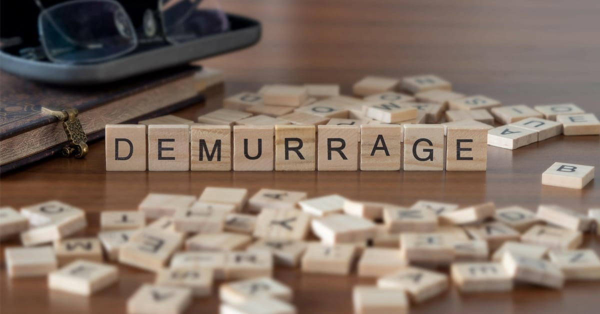 A pile of Scrabble pieces with several standing up to spell Demurrage.