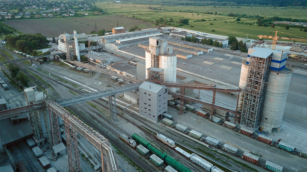Aerial view of railway cargo train cars loaded with construction goods at a mining factory. 