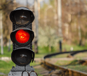 Rail semaphore stoplight with a red signal near a railway.