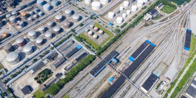 A top down view of a railway marshalling station and petrochemical plant.