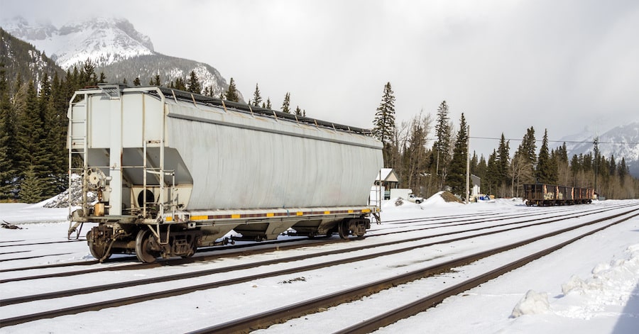 Freight railroad car in snow covered station in the mountains on a winter day.