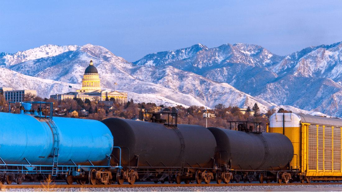 Tank cars in front of a city hall in snowy mountains.